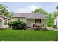 Charming single-story home with a cozy front porch, green lawn, and mature landscaping at 3338 Orchard Ave, Indianapolis, IN 46218