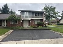Charming two-story townhome with brick facade, upper balcony, and manicured front yard at 3975 Offshore Dr, Columbus, IN 47203