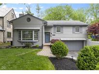 Charming two-story home with landscaped front yard, updated exterior, brick walkway, and attached two car garage at 5543 N Pennsylvania N St, Indianapolis, IN 46220