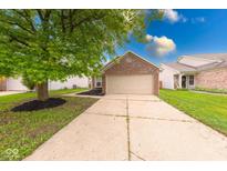Charming brick home featuring an attached garage and a well-maintained front yard at 5633 Fox Glove Ln, Indianapolis, IN 46254