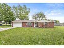 Charming brick home with attached garage and well-maintained lawn and landscaping at 5889 W Homestead Dr, Frankton, IN 46044