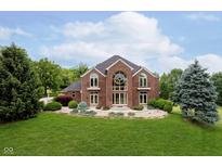 Striking two-story brick home with grand entrance and lush landscaping at 6630 Travis Rd, Greenwood, IN 46143