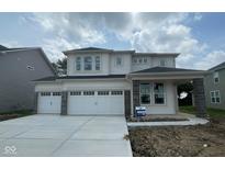 Charming two-story home featuring a three car garage and modern architectural details, enhancing its curb appeal at 6761 Seabiscuit Rd, Whitestown, IN 46075