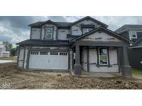 New two-story home showing siding and stone work with an attached two car garage awaiting landscaping at 6849 Seabiscuit Rd, Whitestown, IN 46075