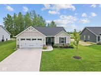 Charming single-story home featuring a manicured lawn, an attached two-car garage, and tasteful landscaping at 7051 E Bean Blossom Dr, Camby, IN 46113