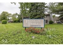 Community sign for Franklin Trails Condominiums with landscaped bushes and trees at 7940 Benjamin Dr, Lawrence, IN 46226