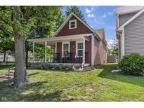 Charming home featuring a cozy front porch with rocking chairs and landscaped yard at 941 N Beville Ave, Indianapolis, IN 46201