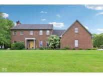 Traditional two-story brick home with a lush lawn and manicured landscaping in a peaceful neighborhood at 1121 N Cambridge Ct, Greenfield, IN 46140