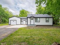 Charming home with a well-maintained lawn and driveway leading to the garage at 1141 Temperance Ave, Indianapolis, IN 46203