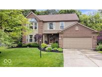 Charming two-story home with brick and siding, lush landscaping, and attached two-car garage at 11956 Glen Cove Dr, Indianapolis, IN 46236