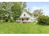 Charming white two-story home featuring a cozy front porch, mature trees, and a well-manicured lawn at 126 N Darlington St, Jamestown, IN 46147
