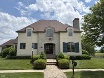 Elegant two-story home featuring a stone facade, brick walkway, manicured lawn and professionally landscaped front yard at 1809 Milford St, Carmel, IN 46032