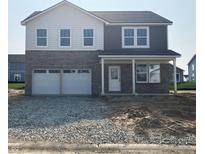 Two story home with a two car garage, covered porch and stone and vinyl siding at 2145 Boxwood Dr, Greenfield, IN 46140