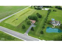 Spacious lot featuring lush green space, charming brick home, pond, and inground pool at 22620 Lamong Rd, Sheridan, IN 46069