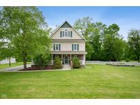 Charming two-story home with a large front yard and beautiful landscaping in a peaceful, wooded setting at 2708 N 400 E, Greenfield, IN 46140