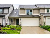 Inviting home featuring a two-car garage, manicured lawn, and charming landscaping at 2949 River Bay N Dr, Indianapolis, IN 46240