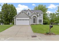 Charming two-story home features a well-manicured lawn and attached two-car garage at 3014 Saddlehorn Dr, Carmel, IN 46033