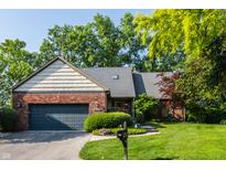 Charming brick home featuring an attached garage and a beautifully maintained lawn at 3585 Bay Rd N Dr, Indianapolis, IN 46240