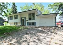 Charming home with light colored siding, updated windows, attached garage, and driveway at 3668 Chatsbee Ct, Indianapolis, IN 46224