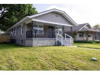 Charming bungalow with stone accents, a cozy front porch, and well-maintained lawn at 3822 Spann Ave, Indianapolis, IN 46203