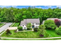Charming home with lush landscaping and a well-manicured lawn, nestled in a serene, tree-filled neighborhood at 5268 Woodfield Dr N, Carmel, IN 46033
