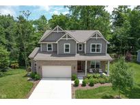 Beautiful two-story home boasts manicured lawn, front porch sitting area, and attached two-car garage at 527 Macintosh Ln, Danville, IN 46122