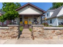 Charming single-story home featuring a welcoming front porch, stone retaining wall and well-manicured landscaping at 60 S 8Th Ave, Beech Grove, IN 46107