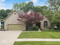Charming brick home with a two-car garage, manicured lawn, and mature trees in a desirable neighborhood at 6363 Harmonridge Ct, Indianapolis, IN 46278