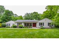Charming single-story home with a manicured lawn and mature trees at 6455 N Olney St, Indianapolis, IN 46220