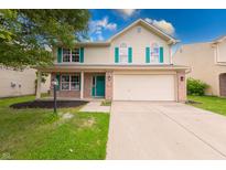 Charming two-story home featuring an attached two-car garage, a lawn, and decorative teal shutters and front door at 705 Treyburn Lakes Way, Indianapolis, IN 46239