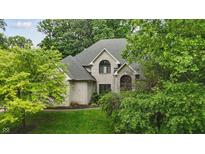 Charming, light brick home with lush greenery and mature trees, offering a serene and private setting at 7138 Nile Ridge Ct, Indianapolis, IN 46236