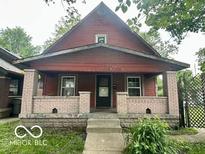 Charming two-story home featuring a covered front porch with brick pillars and a classic design at 721 Haugh St, Indianapolis, IN 46222