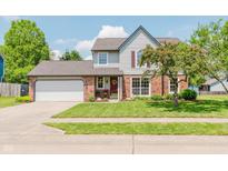 Charming two-story home featuring a brick facade, attached garage, and beautifully landscaped front yard at 7742 Bayridge Dr, Indianapolis, IN 46236