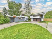 Charming two-story home with well-manicured lawn and a detached two-car garage and unique architectural details at 9080 W Forest Dr, Elwood, IN 46036