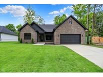Charming brick home with a well-manicured lawn and a two-car garage, providing comfort and curb appeal at 9811 Warren Pl, Indianapolis, IN 46229