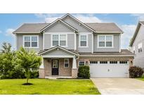 Charming two-story home boasts a blend of gray siding and brick facade, with a well-manicured lawn at 10922 Liberation Trce, Noblesville, IN 46060