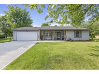 Charming single-story home with a well-manicured lawn and inviting front porch at 1121 Barcelona Dr, Greenwood, IN 46143