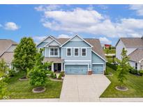 Charming two-story home with blue siding, well-manicured lawn, and a three-car garage at 12672 Amber Star Dr, Noblesville, IN 46060