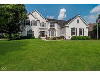 Charming two-story painted brick home with a manicured green lawn at 13218 Beckwith Dr, Carmel, IN 46074