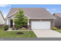 Front exterior of brick home featuring a two-car garage and well-maintained front lawn at 13321 N White Cloud Ct, Camby, IN 46113
