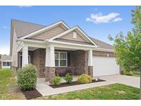 Charming brick home with a covered front porch, white pillars, and manicured landscaping at 13321 N White Cloud Ct, Camby, IN 46113