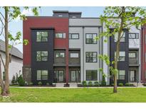 Modern townhouse with mixed brick, black, gray, and red siding and professional landscaping at 1816 Rosette Way, Indianapolis, IN 46202