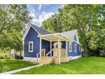Charming blue home featuring a welcoming front porch with wooden railings and lush green lawn at 1822 Howard St, Indianapolis, IN 46221