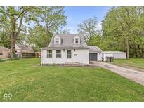 Charming cottage-style home with white siding, dormer windows, green lawn, and attached garage at 2 S 25Th Ave, Beech Grove, IN 46107