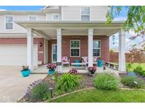 Inviting front porch featuring brick accents, stylish decor, and manicured landscaping at 2337 Hanover Rd, Brownsburg, IN 46112