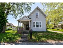 Charming two-story home with a covered porch and landscaped front yard, perfect for enjoying quiet mornings at 31 E Mill St, New Palestine, IN 46163