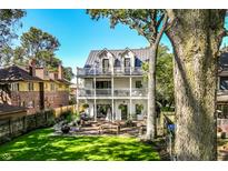 Spacious two-story home with backyard featuring a patio, lush lawn, and mature trees at 3215 N Pennsylvania St, Indianapolis, IN 46205