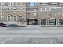 The property's brick exterior includes covered parking and a walkway, all in an urban setting at 350 N Meridian St # A303, Indianapolis, IN 46204