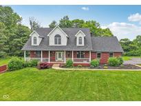 Charming two-story brick home with a welcoming front porch and lush landscaping at 3564 Clear Creek Blvd, Martinsville, IN 46151