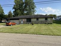 Charming single-story home featuring a well-maintained lawn and a cozy, inviting facade with an attached garage at 409 W 3Rd St, Alexandria, IN 46001